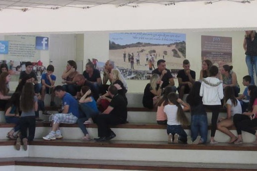 צילום של קבוצה בחוץ יושבת על מדרגות